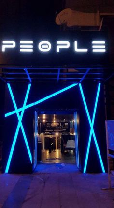 the entrance to people is lit up with neon blue strips and letters that read people