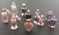 there are many different colored perfume bottles on the table next to each other, including one with a shell