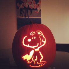 a pumpkin carved to look like a cartoon character with a dog on it's face