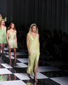 models walk down the runway in green dresses