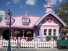 a pink and purple house with hearts on the roof