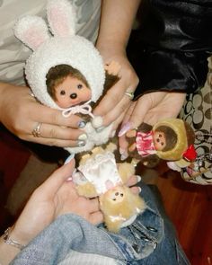 two people holding small stuffed animals in their hands