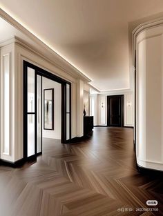 an empty room with white walls and black doors on either side of the door is a chevron wood floor