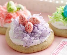 three decorated cookies sitting on top of a pink tray