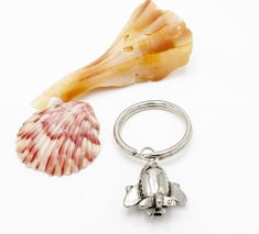 a sea shell and keychain with a seashell in the foreground on a white background