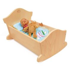 a wooden doll bed with a teddy bear in it