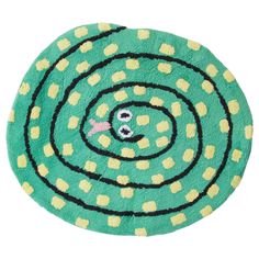 a green rug with yellow dots and a black circle in the center on a white background