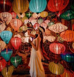 a woman standing in front of many colorful lanterns