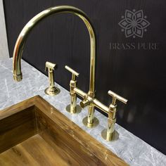 two brass faucets are sitting on the counter