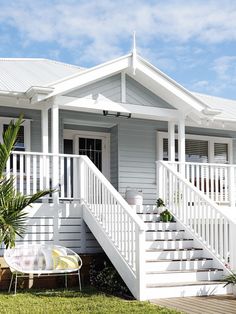 an image of a white house with stairs leading up to the front door and porch