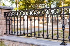 a black iron fence next to a stone wall