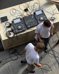 two men are working on some electronic equipment