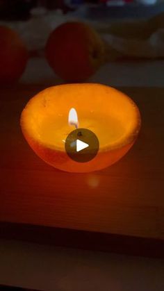 an orange candle sitting on top of a wooden table