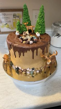 there is a cake that has been decorated with deer and trees on the top of it