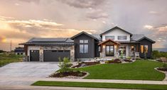 a large house with lots of windows and grass in front of it on a cloudy day