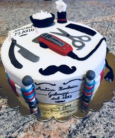 a cake decorated with scissors, mustaches and other items on top of a table