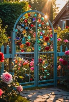 an iron gate with colorful glass beads on it and roses in the foreground at sunset