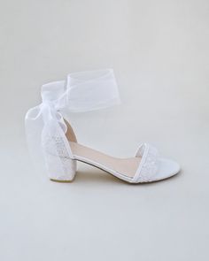 a pair of white shoes with a bow on the front and heel, all tied up