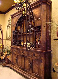 an old wooden china cabinet with flowers on it in a room filled with other furniture