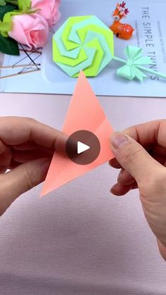 two hands are holding an origami star