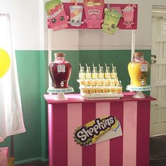 a pink and green candy bar with lots of candies on the table next to it