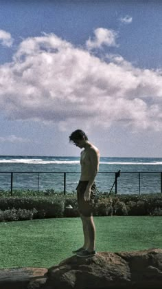 a man standing on top of a rock near the ocean