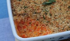 a casserole dish with meat and vegetables in it on a blue table cloth