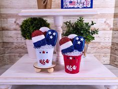 two red, white and blue patriotic buckets with mitts sitting on top of each other