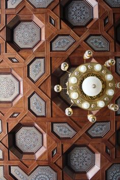 an overhead view of the ceiling in a room with wooden paneling and gold accents