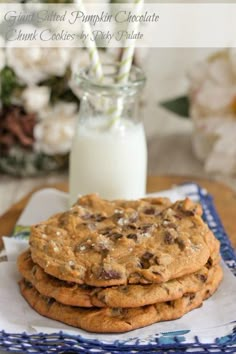 a stack of cookies sitting on top of a table next to a glass of milk