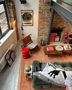 a living room filled with furniture next to a fire place in a brick wall building