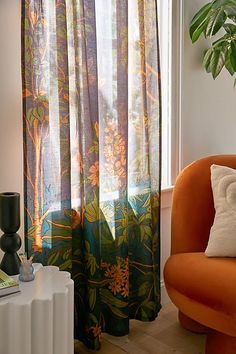 an orange chair sitting in front of a window