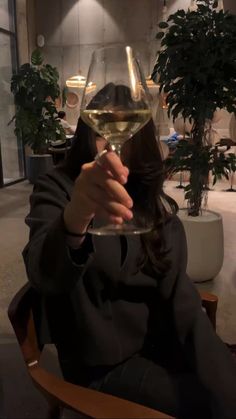 a woman sitting in a chair holding a glass of wine