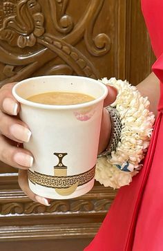 a woman in a red dress holding a cup of coffee