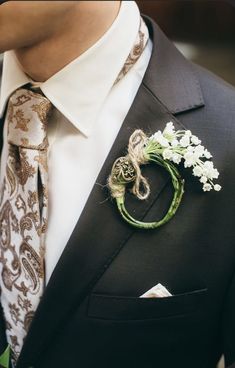 a man wearing a suit and tie with a boutonniere on his lapel