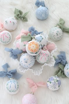 an assortment of decorated easter eggs on a white furnishing with bows and ribbons