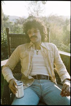 a man sitting in a chair holding a cup