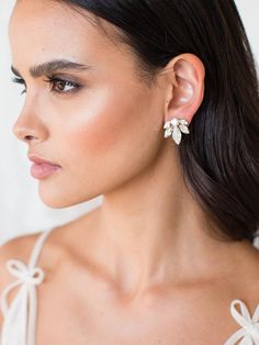 a woman wearing earrings with bows on the back of her head and one ear is shown