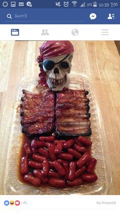 a skull sitting on top of a table covered in bacon and ketchup links