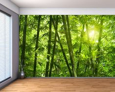 an empty room with wooden floors and green plants on the wall, in front of a window