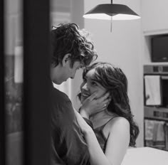 a man standing next to a woman in a kitchen