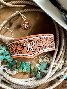 a cowboy hat, rope, and other items on a wooden table with the letter r