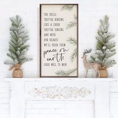 a white fireplace mantle with christmas decorations on it and a framed sign above the mantel