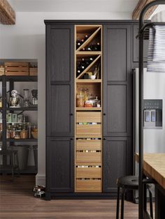 an open cabinet in the middle of a kitchen with lots of drawers and shelves on each side