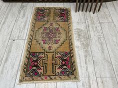 an old rug is laying on the floor next to a wooden slatted bench