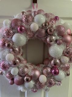 a pink and white christmas ornament wreath