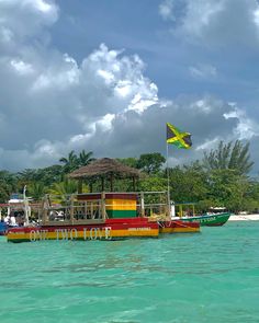 a boat that is floating in the water with people on it and a flag flying