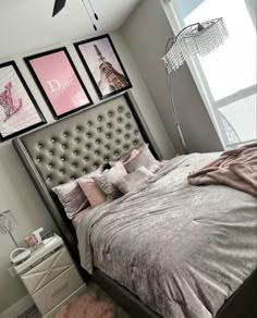 a bedroom with grey walls and pictures on the wall above the bed, along with a pink rug