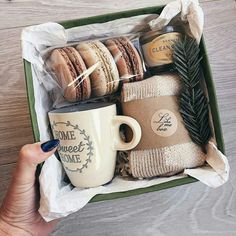 a person holding a coffee cup and some cookies