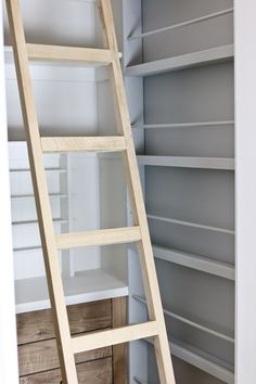 a ladder leaning up against the wall in a closet full of shelves and shelving